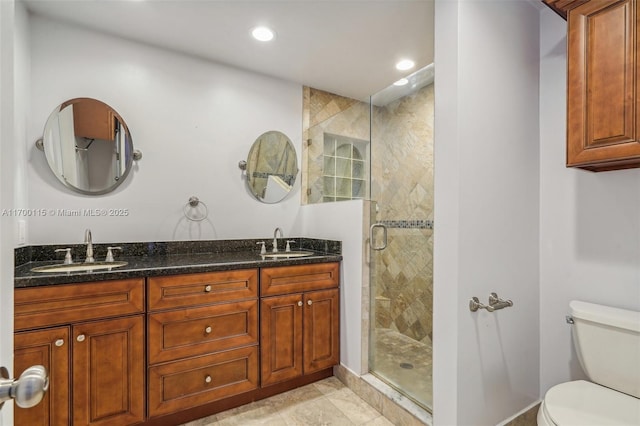 bathroom featuring tile patterned floors, vanity, toilet, and a shower with shower door