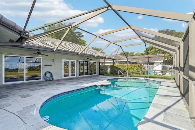 view of pool with glass enclosure, ceiling fan, and a patio area