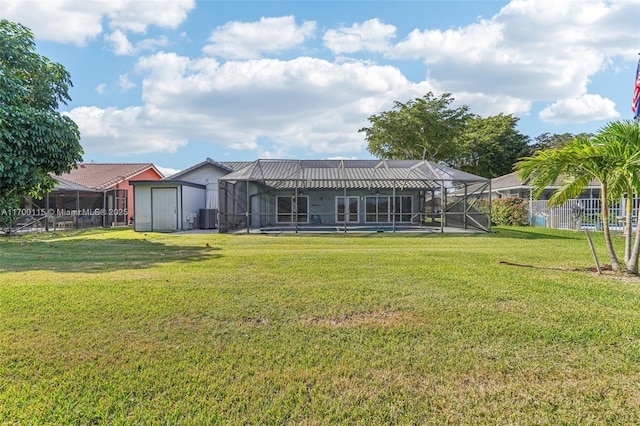 back of house with a lawn, glass enclosure, central AC unit, and a storage shed