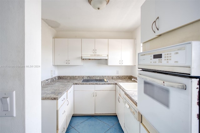 kitchen featuring sink, white cabinets, light tile patterned flooring, and white appliances