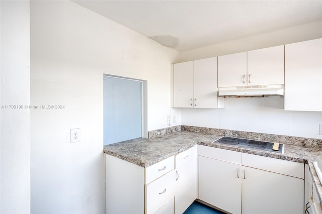 kitchen featuring cooktop and white cabinets