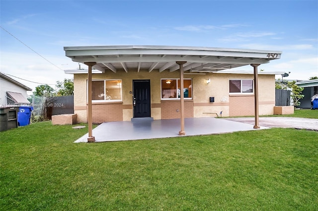 back of property with a lawn and a patio area