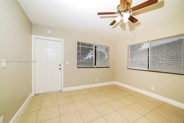 empty room featuring ceiling fan and light tile patterned flooring