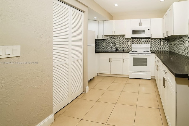 kitchen with white appliances, white cabinets, sink, decorative backsplash, and light tile patterned floors