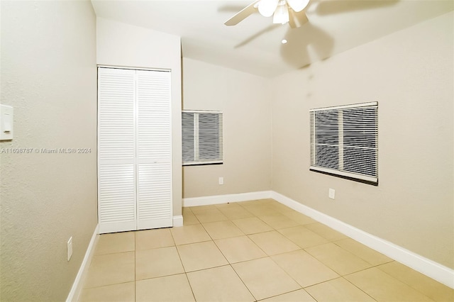 unfurnished bedroom featuring ceiling fan, light tile patterned flooring, and a closet