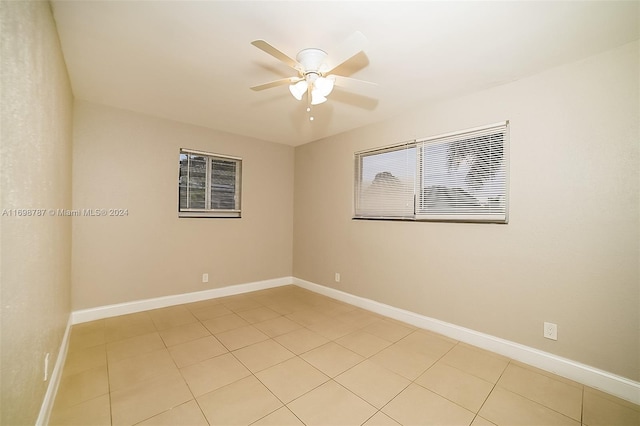 tiled spare room featuring ceiling fan