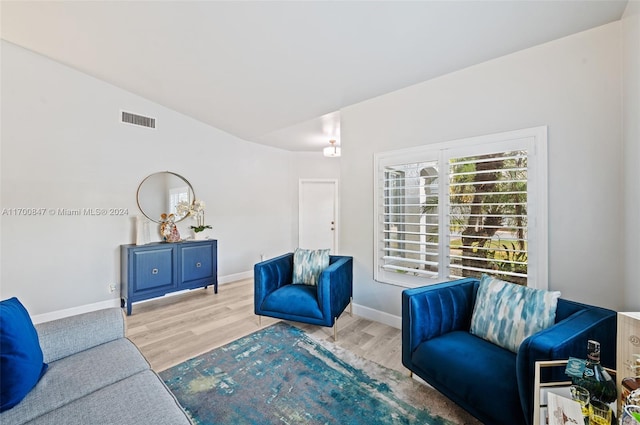 living room with light wood-type flooring and lofted ceiling