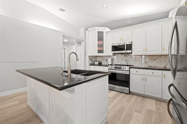 kitchen with stainless steel appliances, white cabinetry, lofted ceiling, and sink