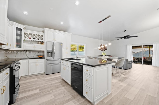 kitchen with white cabinets, appliances with stainless steel finishes, a kitchen island with sink, and sink