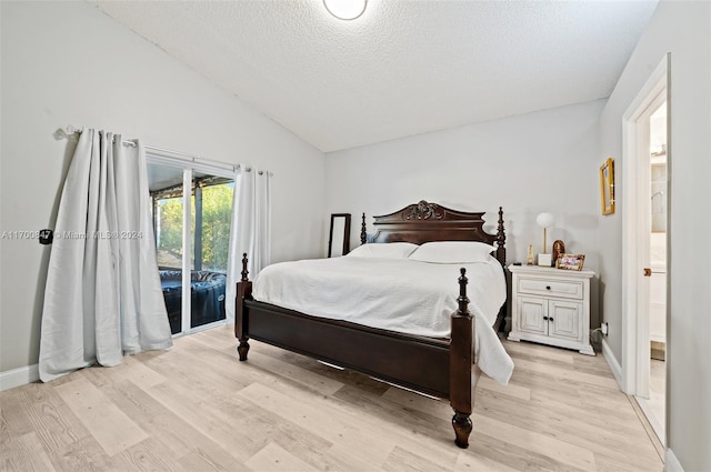 bedroom with light wood-type flooring, ensuite bathroom, a textured ceiling, access to outside, and lofted ceiling