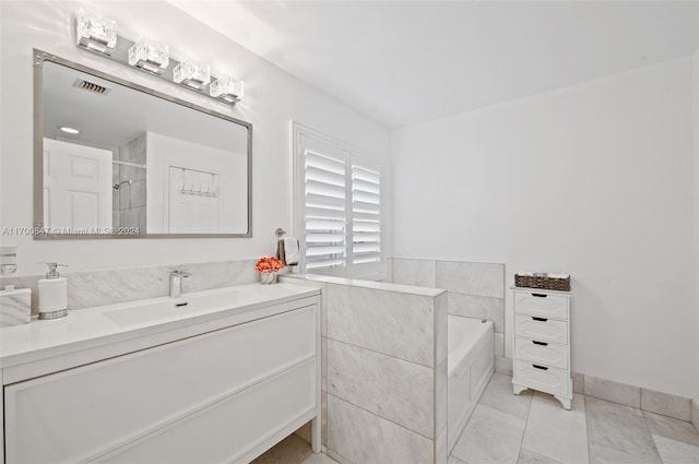 bathroom with tile patterned flooring, a washtub, and vanity