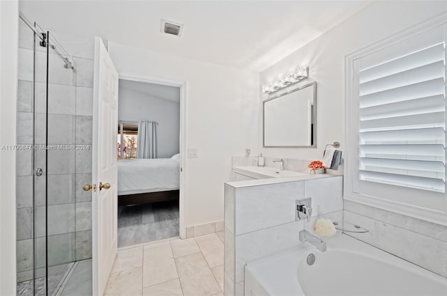 bathroom featuring tile patterned floors, vanity, shower with separate bathtub, and vaulted ceiling