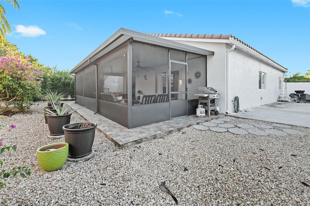 rear view of property with a patio area and a sunroom