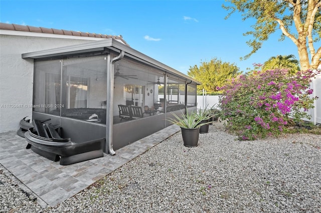 view of patio with a sunroom and ceiling fan