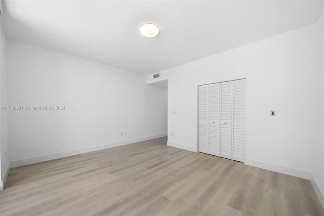 unfurnished bedroom featuring a closet and light wood-type flooring