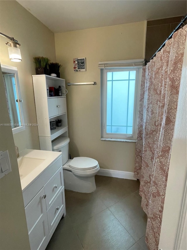 bathroom with tile patterned flooring, vanity, and toilet