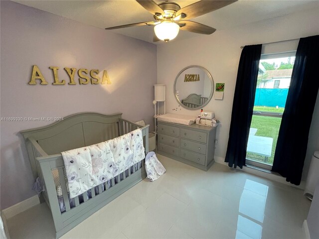 bedroom featuring ceiling fan and a nursery area