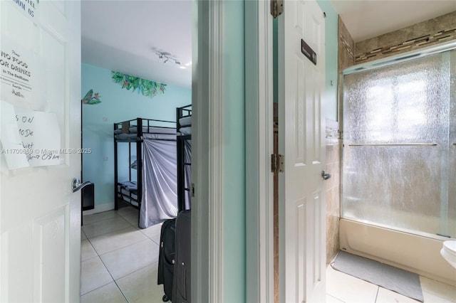 bathroom with combined bath / shower with glass door and tile patterned flooring