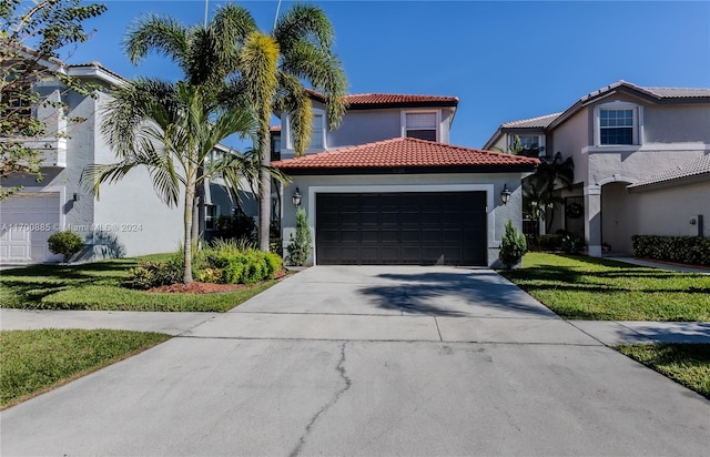 mediterranean / spanish-style home with a front yard and a garage