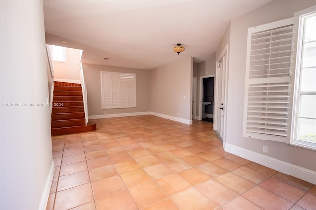 spare room with light tile patterned floors and a textured ceiling