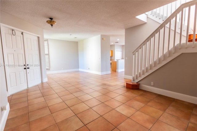 tiled spare room featuring a textured ceiling