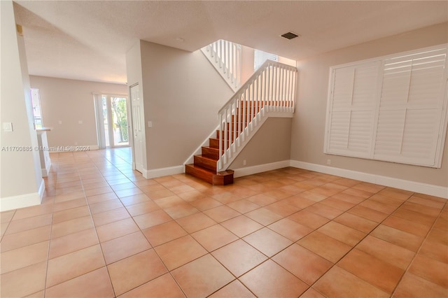 interior space with tile patterned flooring and a textured ceiling