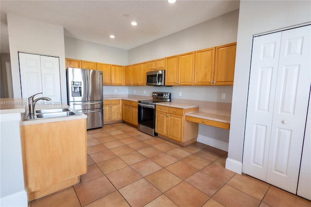 kitchen with sink, light tile patterned flooring, stainless steel appliances, and a textured ceiling