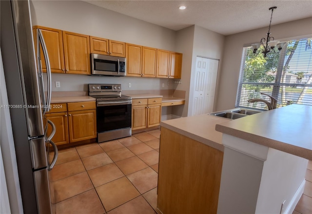 kitchen featuring sink, stainless steel appliances, a chandelier, decorative light fixtures, and light tile patterned floors