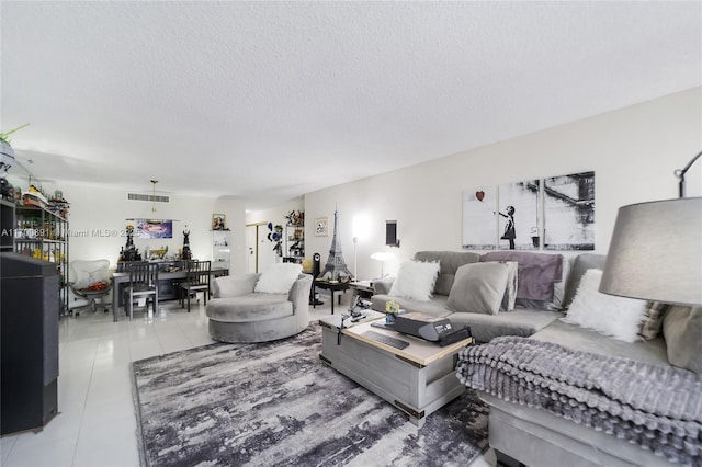 living room featuring visible vents, a textured ceiling, and light tile patterned floors