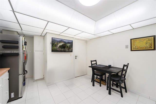 tiled dining room with a drop ceiling