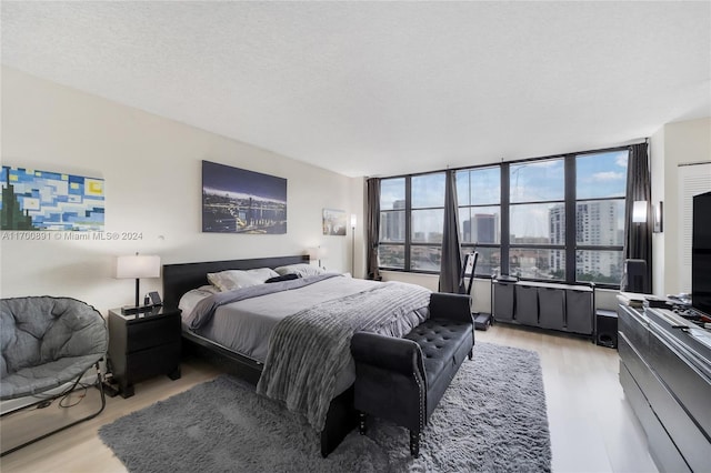 bedroom with light hardwood / wood-style floors and a textured ceiling