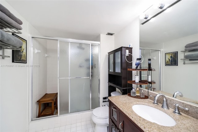 bathroom with toilet, visible vents, vanity, a shower stall, and tile patterned floors