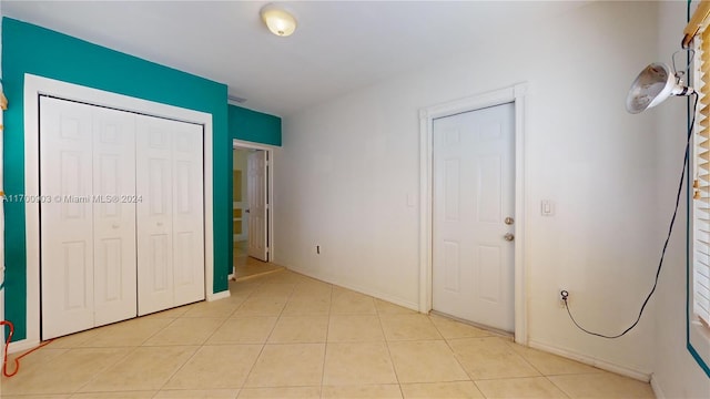 unfurnished bedroom with a closet and light tile patterned floors