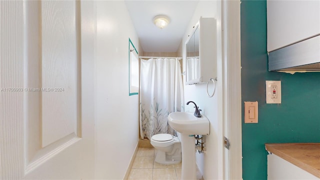 bathroom featuring tile patterned flooring, a shower with shower curtain, toilet, and sink