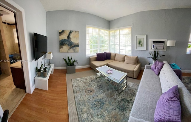 living room featuring wood-type flooring and vaulted ceiling