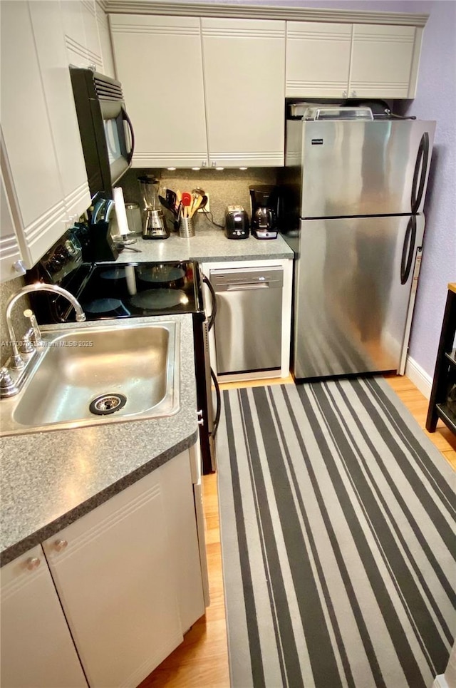 kitchen featuring light hardwood / wood-style floors, sink, white cabinetry, and stainless steel appliances