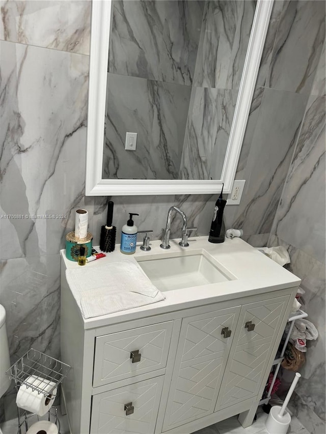 bathroom featuring vanity and tile walls