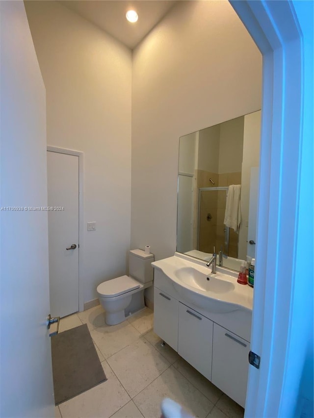 bathroom with toilet, vanity, tile patterned floors, and an enclosed shower