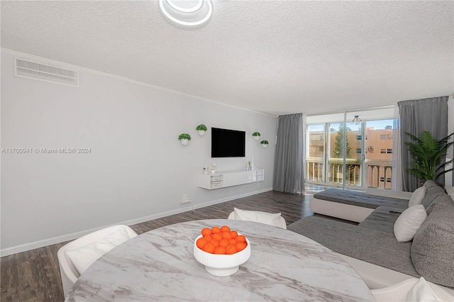 living room featuring dark hardwood / wood-style flooring, a textured ceiling, and ornamental molding