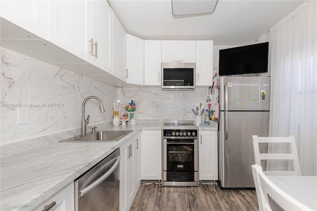 kitchen featuring hardwood / wood-style floors, stainless steel appliances, white cabinetry, and sink