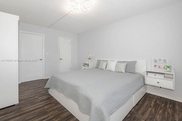 bedroom featuring dark hardwood / wood-style floors and a textured ceiling