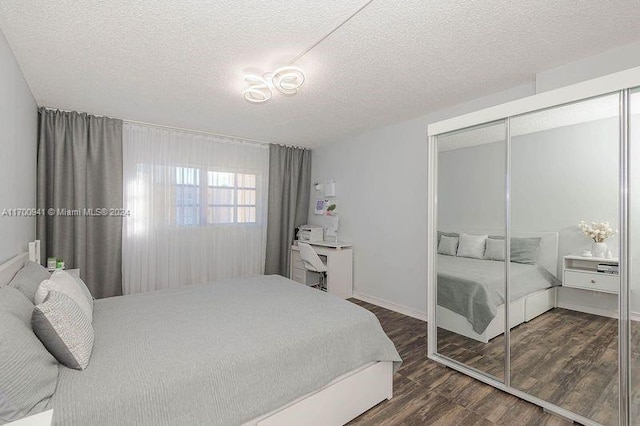 bedroom with a textured ceiling, a closet, and dark wood-type flooring