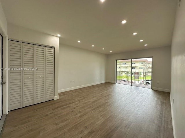 unfurnished bedroom with access to exterior and hardwood / wood-style flooring