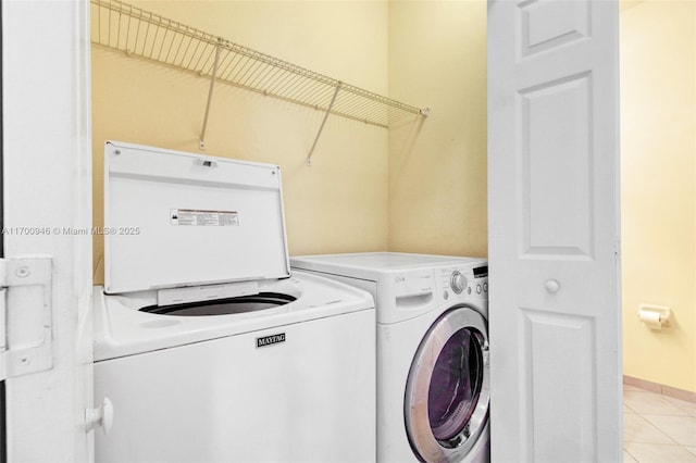 laundry room featuring washer and dryer and light tile patterned floors