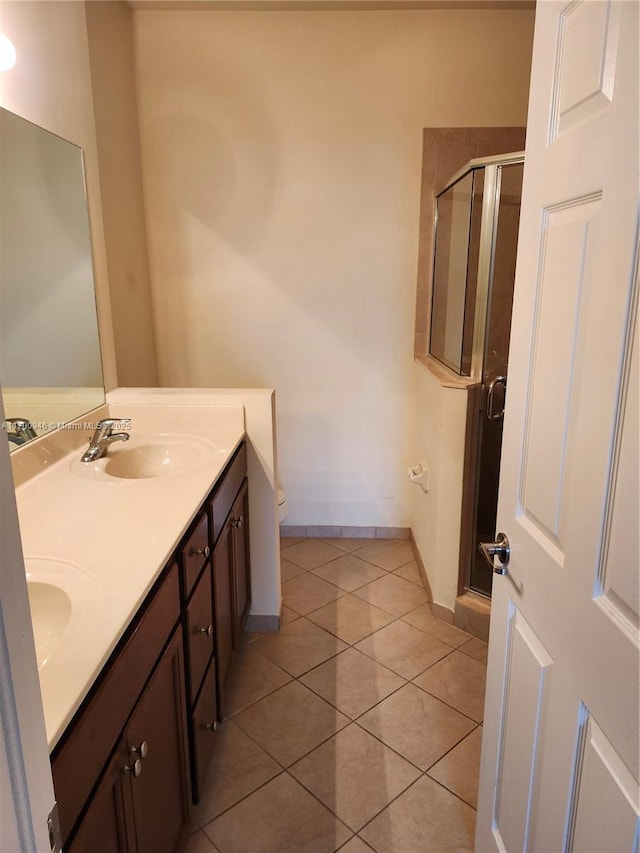 bathroom featuring tile patterned flooring, vanity, a shower with door, and toilet