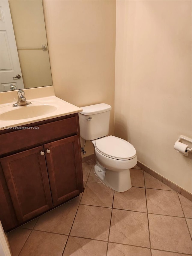 bathroom featuring toilet, vanity, and tile patterned flooring