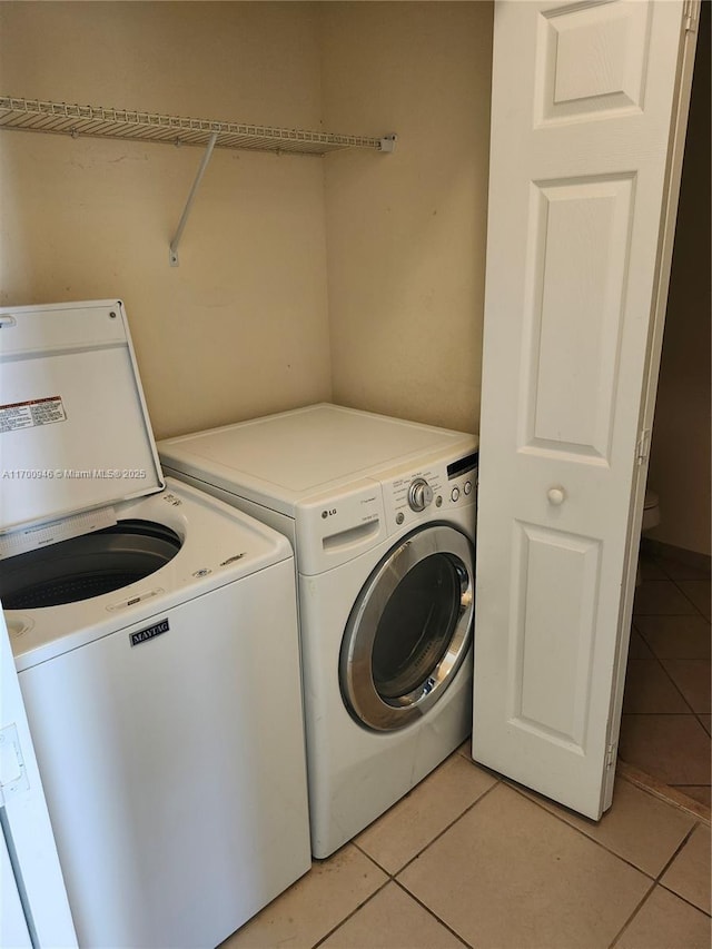 laundry room with light tile patterned flooring and independent washer and dryer