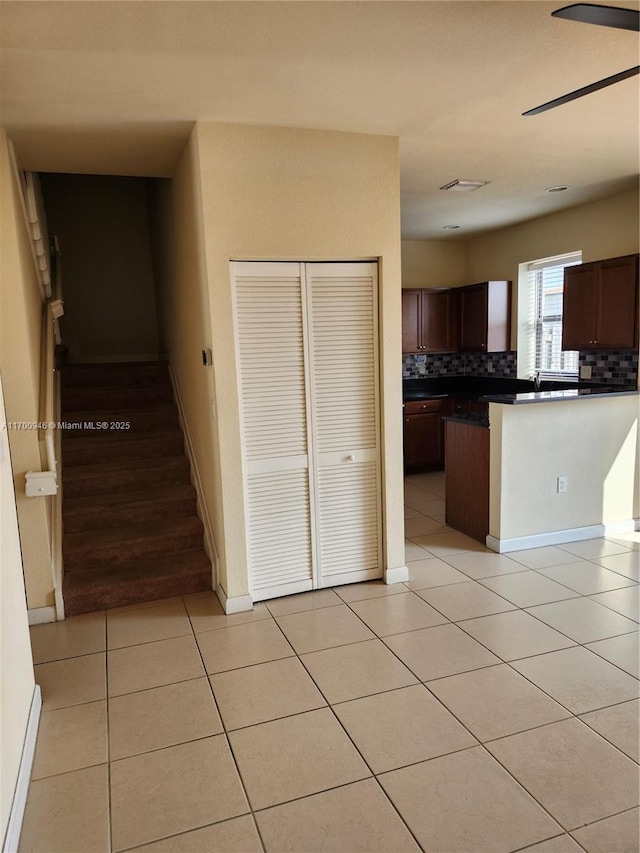 kitchen with ceiling fan, light tile patterned floors, and backsplash