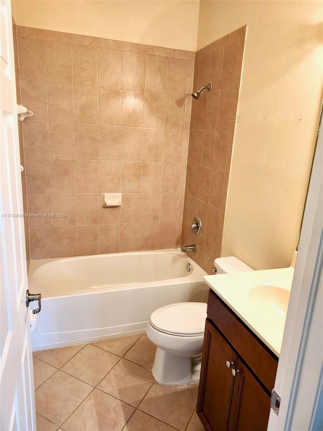 full bathroom featuring toilet, vanity, tiled shower / bath combo, and tile patterned floors