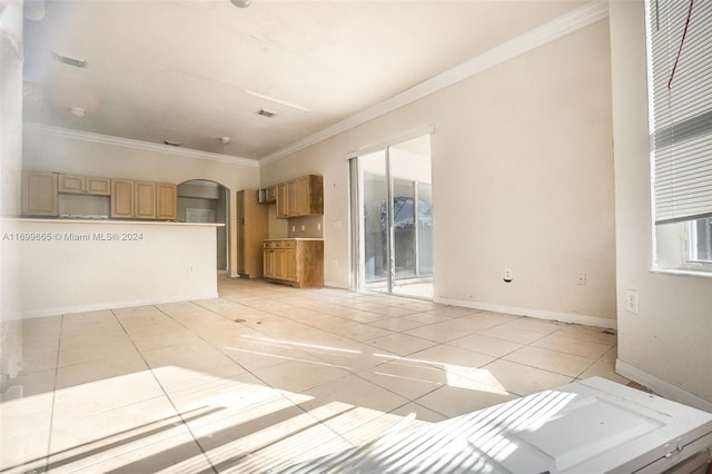 unfurnished living room with light tile patterned flooring and crown molding